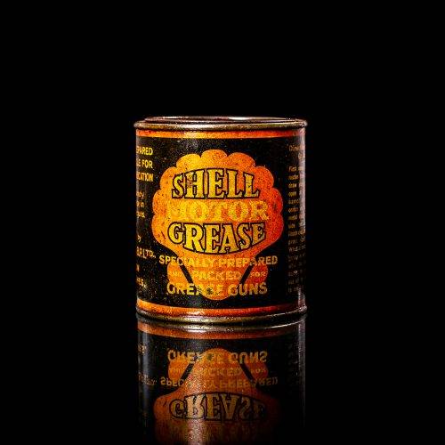 Vintage Shell oil cans with red and yellow branding from the 1900-1920 old logo Vintage Shell oil cans from 1900-19255, featuring the old logo. The photo showcases an antique tin red with yellow accents, displaying the historic Shell emblem. Shot in a studio against a solid black background