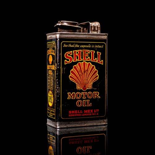 Vintage Shell oil cans with red and yellow branding from the 1900-1920 old logo Vintage Shell oil cans from 1900-19255, featuring the old logo. The photo showcases an antique tin red with yellow accents, displaying the historic Shell emblem. Shot in a studio against a solid black background