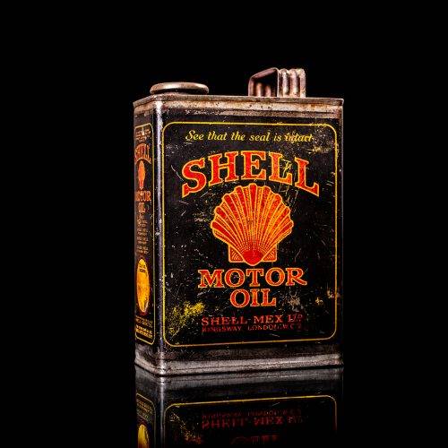 Vintage Shell oil cans with red and yellow branding from the 1900-1920 old logo Vintage Shell oil cans from 1900-19255, featuring the old logo. The photo showcases an antique tin red with yellow accents, displaying the historic Shell emblem. Shot in a studio against a solid black background
