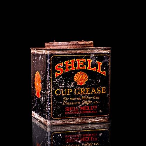 Vintage Shell oil cans with red and yellow branding from the 1900-1920 old logo Vintage Shell oil cans from 1900-19255, featuring the old logo. The photo showcases an antique tin red with yellow accents, displaying the historic Shell emblem. Shot in a studio against a solid black background