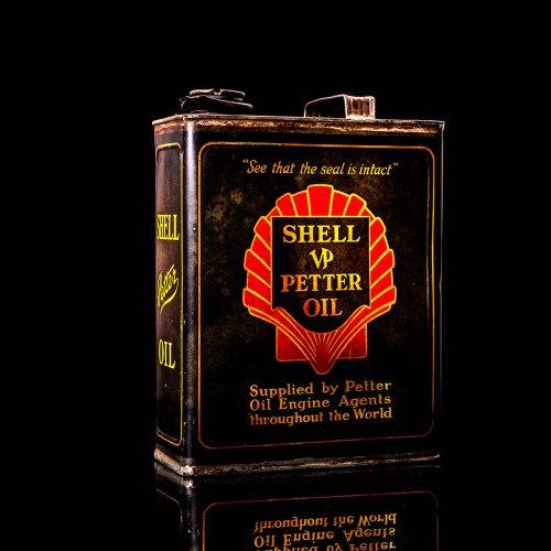 Vintage Shell oil cans with red and yellow branding from the 1900-1920 old logo Vintage Shell oil cans from 1900-19255, featuring the old logo. The photo showcases an antique tin red with yellow accents, displaying the historic Shell emblem. Shot in a studio against a solid black background