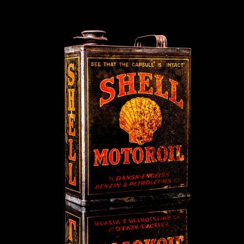 Vintage Shell oil cans with red and yellow branding from the 1900-1920 old logo Vintage Shell oil cans from 1900-19255, featuring the old logo. The photo showcases an antique tin red with yellow accents, displaying the historic Shell emblem. Shot in a studio against a solid black background