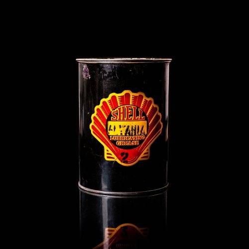 Vintage Shell oil cans with red and yellow branding from the 1900-1920 old logo Vintage Shell oil cans from 1900-19255, featuring the old logo. The photo showcases an antique tin red with yellow accents, displaying the historic Shell emblem. Shot in a studio against a solid black background