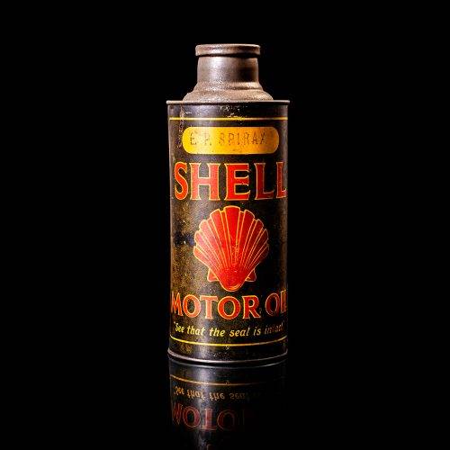 Vintage Shell oil cans with red and yellow branding from the 1900-1920 old logo Vintage Shell oil cans from 1900-19255, featuring the old logo. The photo showcases an antique tin red with yellow accents, displaying the historic Shell emblem. Shot in a studio against a solid black background