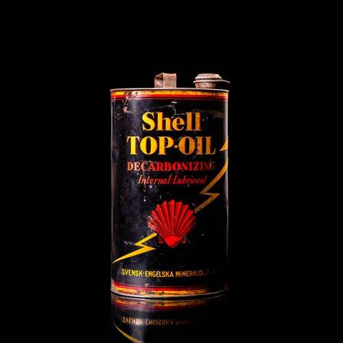 Vintage Shell oil cans with red and yellow branding from the 1900-1920 old logo Vintage Shell oil cans from 1900-19255, featuring the old logo. The photo showcases an antique tin red with yellow accents, displaying the historic Shell emblem. Shot in a studio against a solid black background