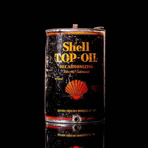 Vintage Shell oil cans with red and yellow branding from the 1900-1920 old logo Vintage Shell oil cans from 1900-19255, featuring the old logo. The photo showcases an antique tin red with yellow accents, displaying the historic Shell emblem. Shot in a studio against a solid black background