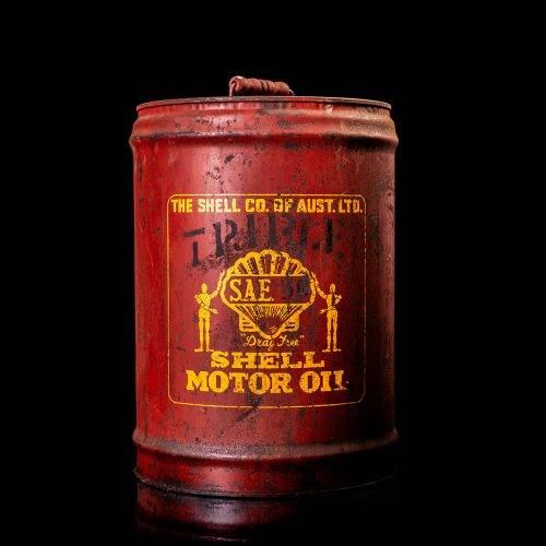Vintage Shell oil cans with red and yellow branding from the 1900-1920 old logo Vintage Shell oil cans from 1900-19255, featuring the old logo. The photo showcases an antique tin red with yellow accents, displaying the historic Shell emblem. Shot in a studio against a solid black background