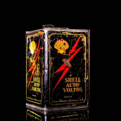 Vintage Shell oil cans with red and yellow branding from the 1900-1920 old logo Vintage Shell oil cans from 1900-19255, featuring the old logo. The photo showcases an antique tin red with yellow accents, displaying the historic Shell emblem. Shot in a studio against a solid black background