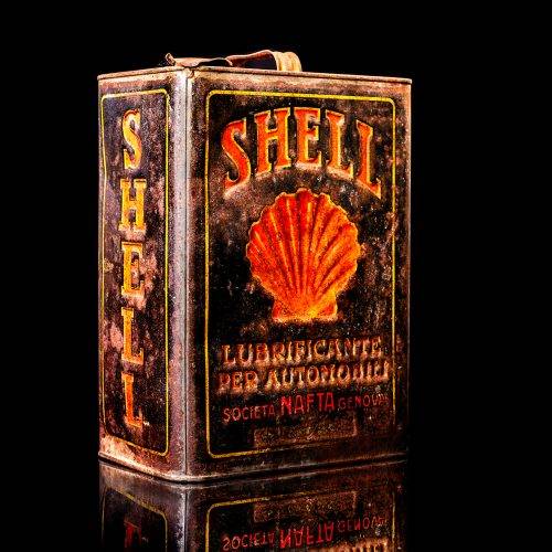 Vintage Shell oil cans with red and yellow branding from the 1900-1920 old logo Vintage Shell oil cans from 1900-19255, featuring the old logo. The photo showcases an antique tin red with yellow accents, displaying the historic Shell emblem. Shot in a studio against a solid black background