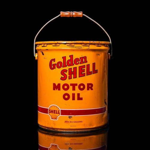 Vintage Shell oil cans with red and yellow branding from the 1900-1920 old logo Vintage Shell oil cans from 1900-19255, featuring the old logo. The photo showcases an antique tin red with yellow accents, displaying the historic Shell emblem. Shot in a studio against a solid black background