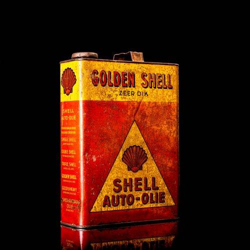 Vintage Shell oil cans with red and yellow branding from the 1900-1920 old logo Vintage Shell oil cans from 1900-19255, featuring the old logo. The photo showcases an antique tin red with yellow accents, displaying the historic Shell emblem. Shot in a studio against a solid black background