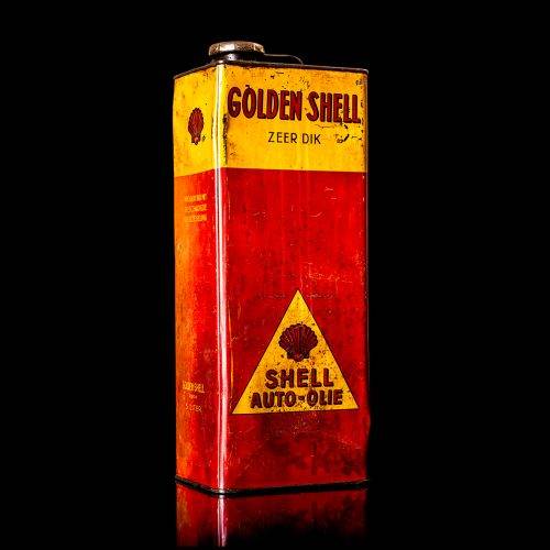 Vintage Shell oil cans with red and yellow branding from the 1900-1920 old logo Vintage Shell oil cans from 1900-19255, featuring the old logo. The photo showcases an antique tin red with yellow accents, displaying the historic Shell emblem. Shot in a studio against a solid black background