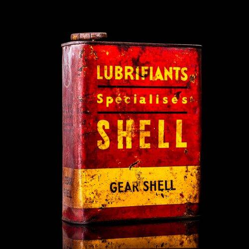 Vintage Shell oil cans with red and yellow branding from the 1900-1920 old logo Vintage Shell oil cans from 1900-19255, featuring the old logo. The photo showcases an antique tin red with yellow accents, displaying the historic Shell emblem. Shot in a studio against a solid black background