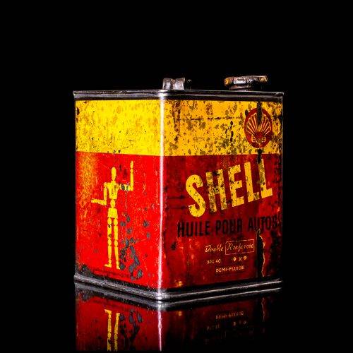 Vintage Shell oil cans with red and yellow branding from the 1900-1920 old logo Vintage Shell oil cans from 1900-19255, featuring the old logo. The photo showcases an antique tin red with yellow accents, displaying the historic Shell emblem. Shot in a studio against a solid black background