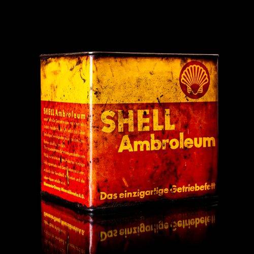Vintage Shell oil cans with red and yellow branding from the 1900-1920 old logo Vintage Shell oil cans from 1900-19255, featuring the old logo. The photo showcases an antique tin red with yellow accents, displaying the historic Shell emblem. Shot in a studio against a solid black background