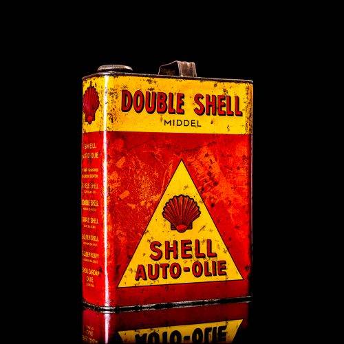 Vintage Shell oil cans with red and yellow branding from the 1900-1920 old logo Vintage Shell oil cans from 1900-19255, featuring the old logo. The photo showcases an antique tin red with yellow accents, displaying the historic Shell emblem. Shot in a studio against a solid black background