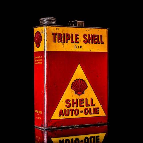 Vintage Shell oil cans with red and yellow branding from the 1900-1920 old logo Vintage Shell oil cans from 1900-19255, featuring the old logo. The photo showcases an antique tin red with yellow accents, displaying the historic Shell emblem. Shot in a studio against a solid black background
