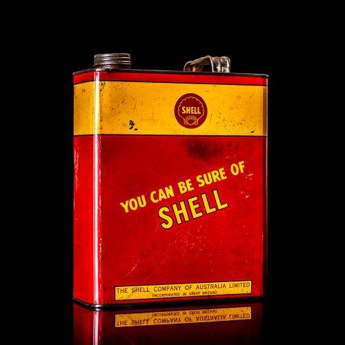 Vintage Shell oil cans with red and yellow branding from the 1900-1920 old logo Vintage Shell oil cans from 1900-19255, featuring the old logo. The photo showcases an antique tin red with yellow accents, displaying the historic Shell emblem. Shot in a studio against a solid black background