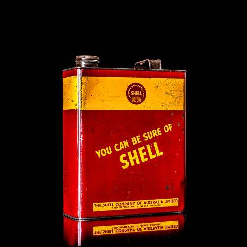Vintage Shell oil cans with red and yellow branding from the 1900-1920 old logo Vintage Shell oil cans from 1900-19255, featuring the old logo. The photo showcases an antique tin red with yellow accents, displaying the historic Shell emblem. Shot in a studio against a solid black background
