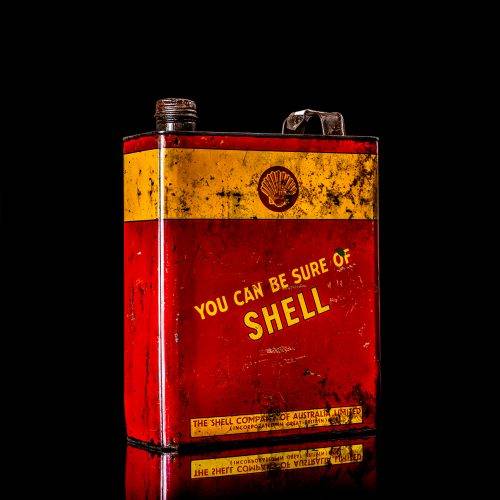 Vintage Shell oil cans with red and yellow branding from the 1900-1920 old logo Vintage Shell oil cans from 1900-19255, featuring the old logo. The photo showcases an antique tin red with yellow accents, displaying the historic Shell emblem. Shot in a studio against a solid black background