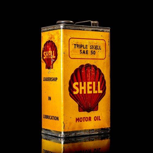 Vintage Shell oil cans with red and yellow branding from the 1900-1920 old logo Vintage Shell oil cans from 1900-19255, featuring the old logo. The photo showcases an antique tin red with yellow accents, displaying the historic Shell emblem. Shot in a studio against a solid black background