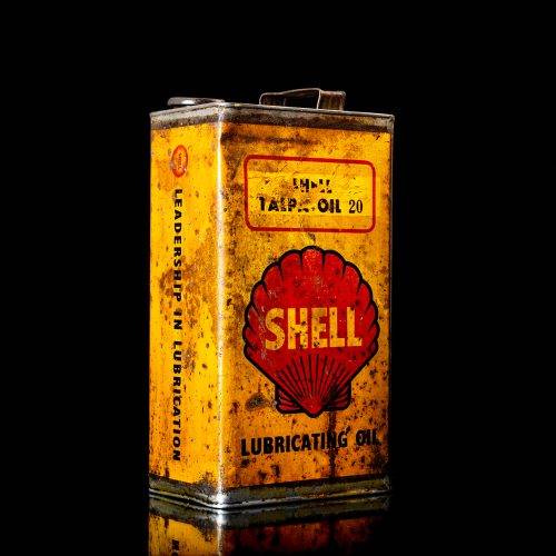 Vintage Shell oil cans with red and yellow branding from the 1900-1920 old logo Vintage Shell oil cans from 1900-19255, featuring the old logo. The photo showcases an antique tin red with yellow accents, displaying the historic Shell emblem. Shot in a studio against a solid black background