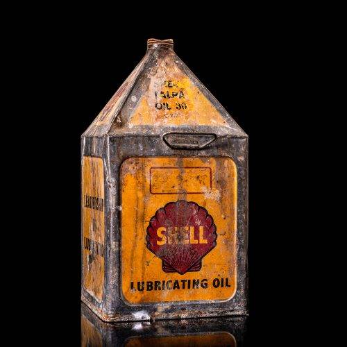Vintage Shell oil cans with red and yellow branding from the 1900-1920 old logo Vintage Shell oil cans from 1900-19255, featuring the old logo. The photo showcases an antique tin red with yellow accents, displaying the historic Shell emblem. Shot in a studio against a solid black background