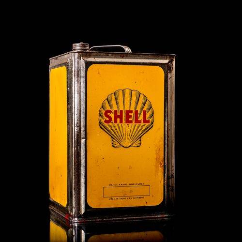 Vintage Shell oil cans with red and yellow branding from the 1900-1920 old logo Vintage Shell oil cans from 1900-19255, featuring the old logo. The photo showcases an antique tin red with yellow accents, displaying the historic Shell emblem. Shot in a studio against a solid black background