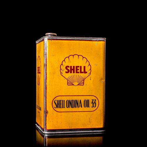 Vintage Shell oil cans with red and yellow branding from the 1900-1920 old logo Vintage Shell oil cans from 1900-19255, featuring the old logo. The photo showcases an antique tin red with yellow accents, displaying the historic Shell emblem. Shot in a studio against a solid black background