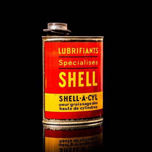 Vintage Shell oil cans with red and yellow branding from the 1900-1920 old logo Vintage Shell oil cans from 1900-19255, featuring the old logo. The photo showcases an antique tin red with yellow accents, displaying the historic Shell emblem. Shot in a studio against a solid black background