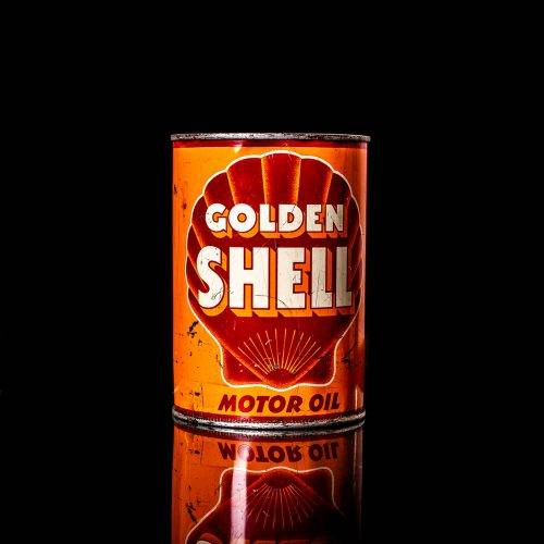 Vintage Shell oil cans with red and yellow branding from the 1900-1920 old logo Vintage Shell oil cans from 1900-19255, featuring the old logo. The photo showcases an antique tin red with yellow accents, displaying the historic Shell emblem. Shot in a studio against a solid black background