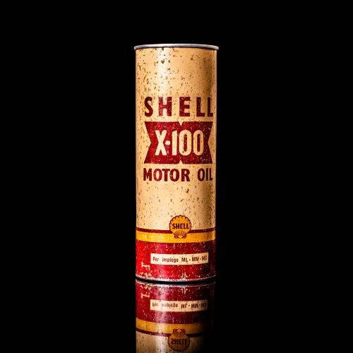 Vintage Shell oil cans with red and yellow branding from the 1900-1920 old logo Vintage Shell oil cans from 1900-19255, featuring the old logo. The photo showcases an antique tin red with yellow accents, displaying the historic Shell emblem. Shot in a studio against a solid black background