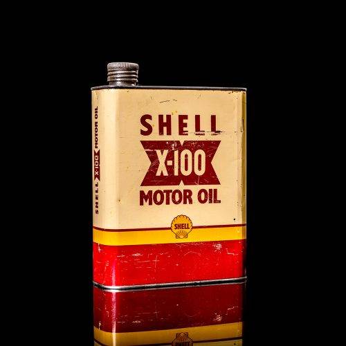 Vintage Shell oil cans with red and yellow branding from the 1900-1920 old logo Vintage Shell oil cans from 1900-19255, featuring the old logo. The photo showcases an antique tin red with yellow accents, displaying the historic Shell emblem. Shot in a studio against a solid black background