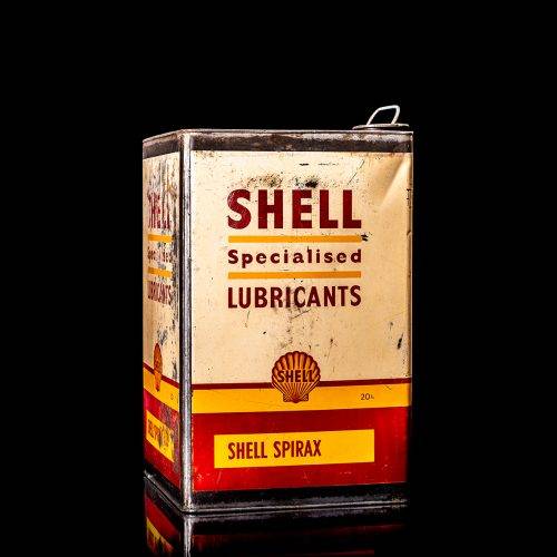 Vintage Shell oil cans with red and yellow branding from the 1900-1920 old logo Vintage Shell oil cans from 1900-19255, featuring the old logo. The photo showcases an antique tin red with yellow accents, displaying the historic Shell emblem. Shot in a studio against a solid black background