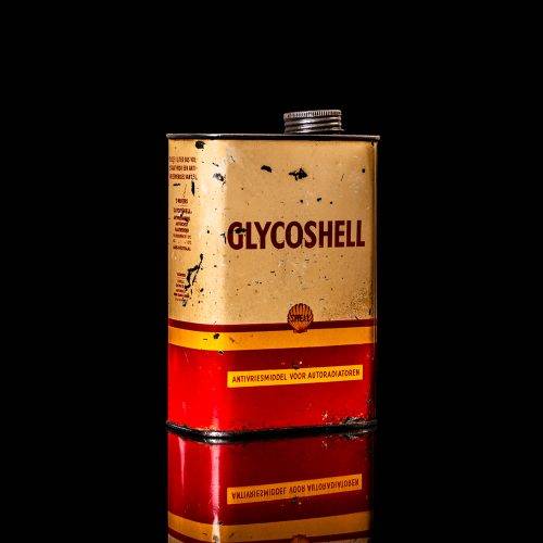 Vintage Shell oil cans with red and yellow branding from the 1900-1920 old logo Vintage Shell oil cans from 1900-19255, featuring the old logo. The photo showcases an antique tin red with yellow accents, displaying the historic Shell emblem. Shot in a studio against a solid black background