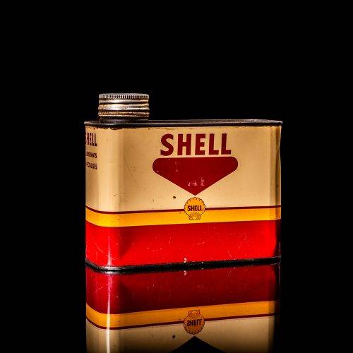 Vintage Shell oil cans with red and yellow branding from the 1900-1920 old logo Vintage Shell oil cans from 1900-19255, featuring the old logo. The photo showcases an antique tin red with yellow accents, displaying the historic Shell emblem. Shot in a studio against a solid black background