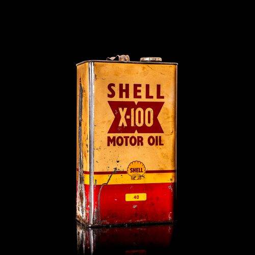 Vintage Shell oil cans with red and yellow branding from the 1900-1920 old logo Vintage Shell oil cans from 1900-19255, featuring the old logo. The photo showcases an antique tin red with yellow accents, displaying the historic Shell emblem. Shot in a studio against a solid black background