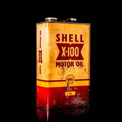 Vintage Shell oil cans with red and yellow branding from the 1900-1920 old logo Vintage Shell oil cans from 1900-19255, featuring the old logo. The photo showcases an antique tin red with yellow accents, displaying the historic Shell emblem. Shot in a studio against a solid black background