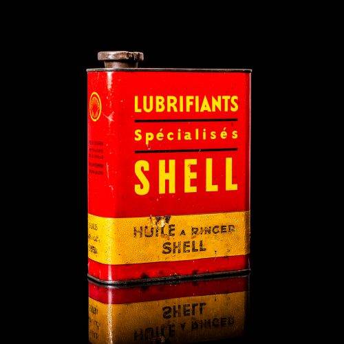 Vintage Shell oil cans with red and yellow branding from the 1900-1920 old logo Vintage Shell oil cans from 1900-19255, featuring the old logo. The photo showcases an antique tin red with yellow accents, displaying the historic Shell emblem. Shot in a studio against a solid black background