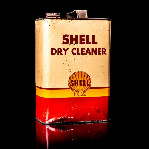Vintage Shell oil cans with red and yellow branding from the 1900-1920 old logo Vintage Shell oil cans from 1900-19255, featuring the old logo. The photo showcases an antique tin red with yellow accents, displaying the historic Shell emblem. Shot in a studio against a solid black background