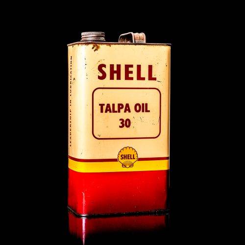 Vintage Shell oil cans with red and yellow branding from the 1900-1920 old logo Vintage Shell oil cans from 1900-19255, featuring the old logo. The photo showcases an antique tin red with yellow accents, displaying the historic Shell emblem. Shot in a studio against a solid black background