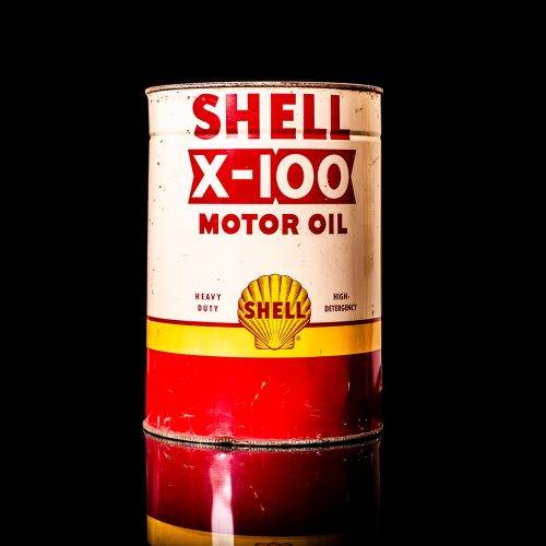 Vintage Shell oil cans with red and yellow branding from the 1900-1920 old logo Vintage Shell oil cans from 1900-19255, featuring the old logo. The photo showcases an antique tin red with yellow accents, displaying the historic Shell emblem. Shot in a studio against a solid black background