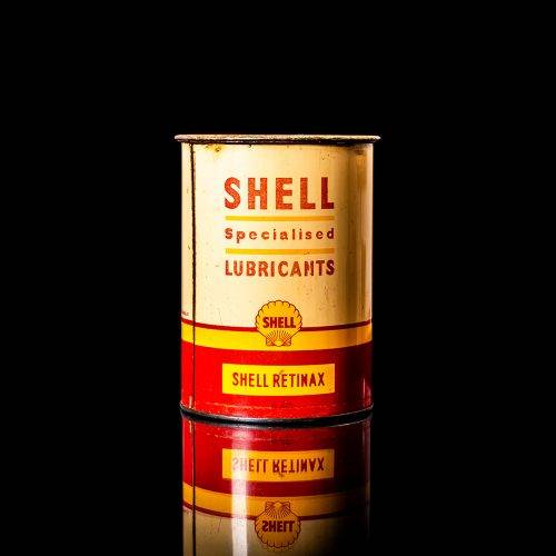 Vintage Shell oil cans with red and yellow branding from the 1900-1920 old logo Vintage Shell oil cans from 1900-19255, featuring the old logo. The photo showcases an antique tin red with yellow accents, displaying the historic Shell emblem. Shot in a studio against a solid black background