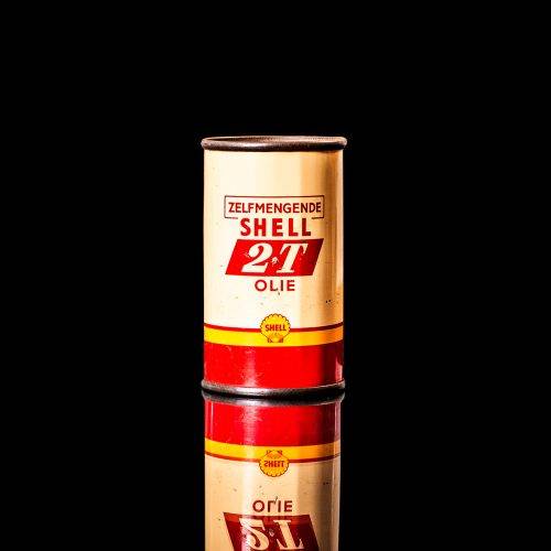 Vintage Shell oil can from 1950–1960 with white base color, yellow and red accents, and the classic Shell logo. Antique motor oil tin displayed in a studio setting against a solid black background."