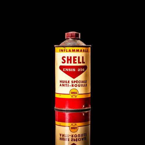 Vintage Shell oil cans with red and yellow branding from the 1900-1920 old logo Vintage Shell oil cans from 1900-19255, featuring the old logo. The photo showcases an antique tin red with yellow accents, displaying the historic Shell emblem. Shot in a studio against a solid black background