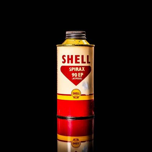 Vintage Shell oil cans with red and yellow branding from the 1900-1920 old logo Vintage Shell oil cans from 1900-19255, featuring the old logo. The photo showcases an antique tin red with yellow accents, displaying the historic Shell emblem. Shot in a studio against a solid black background