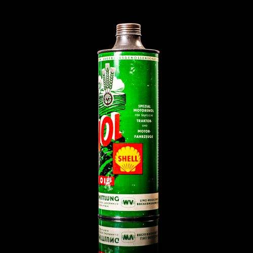 Vintage Shell oil cans with red and yellow branding from the 1900-1920 old logo Vintage Shell oil cans from 1900-19255, featuring the old logo. The photo showcases an antique tin red with yellow accents, displaying the historic Shell emblem. Shot in a studio against a solid black background