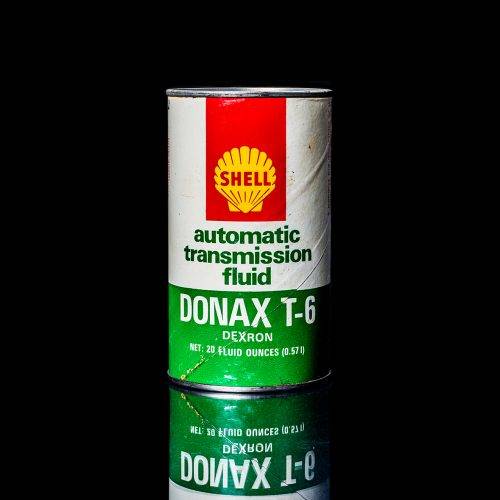 Vintage Shell oil cans with red and yellow branding from the 1900-1920 old logo Vintage Shell oil cans from 1900-19255, featuring the old logo. The photo showcases an antique tin red with yellow accents, displaying the historic Shell emblem. Shot in a studio against a solid black background