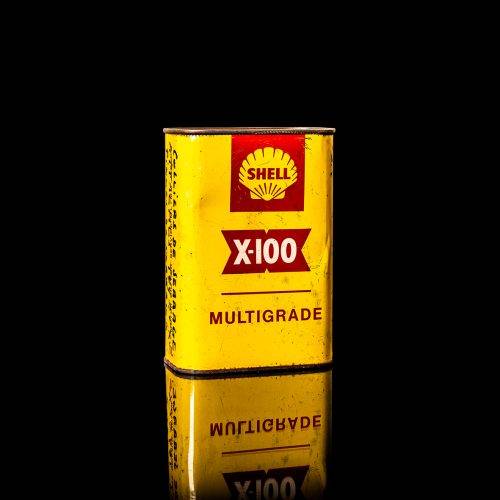 Vintage Shell oil cans with red and yellow branding from the 1900-1920 old logo Vintage Shell oil cans from 1900-19255, featuring the old logo. The photo showcases an antique tin red with yellow accents, displaying the historic Shell emblem. Shot in a studio against a solid black background