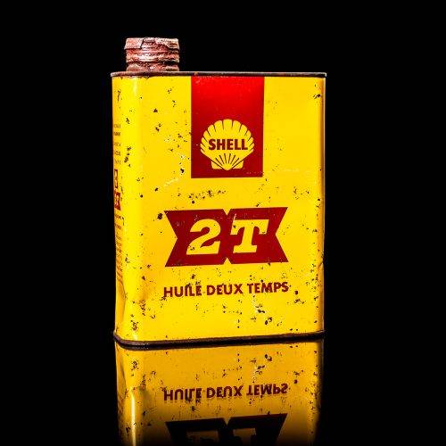 Vintage Shell oil cans with red and yellow branding from the 1900-1920 old logo Vintage Shell oil cans from 1900-19255, featuring the old logo. The photo showcases an antique tin red with yellow accents, displaying the historic Shell emblem. Shot in a studio against a solid black background